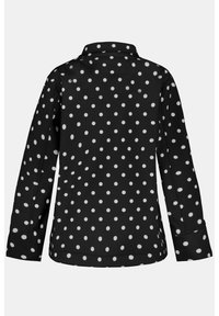 Camisa negra con lunares blancos, de manga larga, con cuello y puños. Textura suave con corte recto y dobladillo lateral.