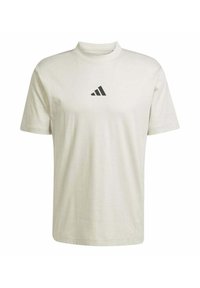 Camiseta de algodón crema de manga corta con cuello alto y un triángulo negro del logo de Adidas en el pecho. Textura suave y corte clásico.