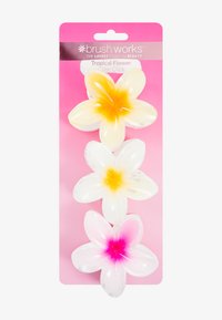Tre klämspännen formade som tropiska blommor i vitt, gult och rosa, placerade på en rosa bakgrund. Glansigt plastmaterial, varje klämma har en färgövergång.