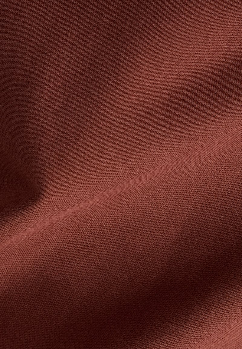 Brown stretch fabric with a smooth texture and a slight sheen, featuring a tight weave and light creases, indicating drape and flexibility.