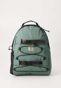 Groene stoffen rugzak met zwarte accenten. Voorzien van een bovenhandvat, verstelbare schouderbanden, een voorste gesp en een logo-patch. Inclusief een mesh zijvak.