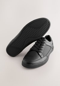 Sneakers nere con tomaia in pelle, dettagli in mesh testurizzato e suola in gomma con battistrada sagomato per una maggiore aderenza. Design con lacci.