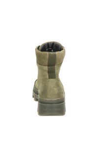 Botín de ante verde con suela de goma, talón reforzado y panel lateral elástico para poner y quitar fácilmente. Suela plana y texturizada para mayor agarre.