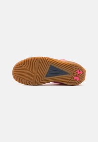 Gumi talp, zigzag mintázattal, sötétkék akcentussal és rózsaszín Under Armour logóval. Texturált tapadás és vonóerő érdekében.