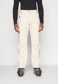 Lys beige skibukser med rett passform, laget av holdbart materiale. Har glidelåslommer og justerbar midje.