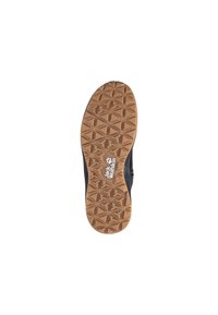 Semelle en caoutchouc avec un motif texturé et géométrique en beige, avec un logo blanc bien en vue. La tige de la chaussure est cachée.