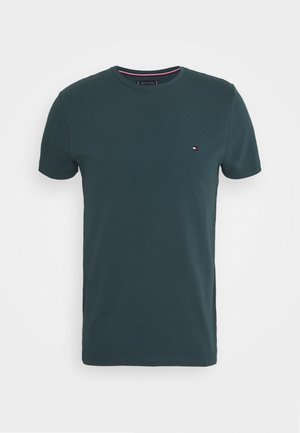 Grøn bomulds T-shirt med korte ærmer og rund hals, med et lille emblem på venstre bryst. Glat tekstur, afslappet pasform.