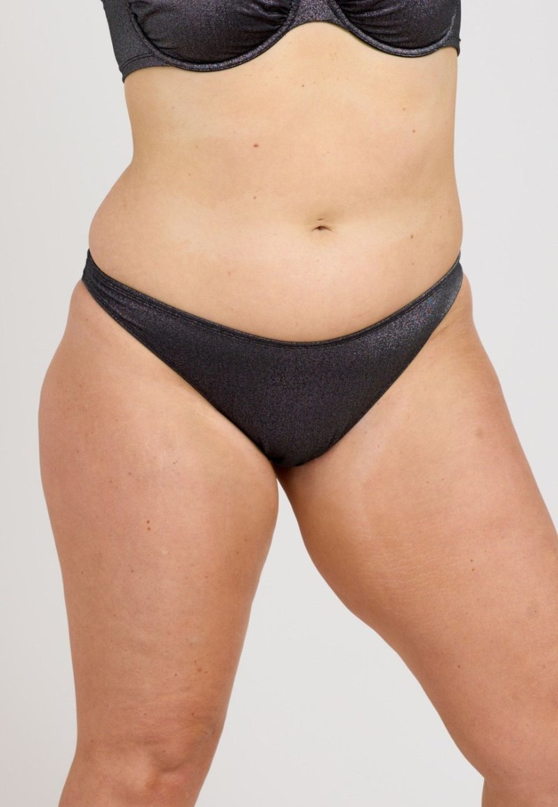 Högmidjade bikinibyxor i metalliskt svart. Tillverkade av mjukt, stretchigt material med en slät yta och minimalistisk design.