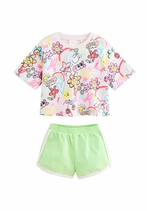 Top corto a maniche corte in tonalità pastello con stampe di fiori e stelle colorati; abbinato a pantaloni corti verde menta con bordi bianchi e cintura elastica.