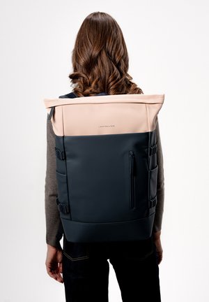 Zaino impermeabile nero e rosa chiaro con spallacci regolabili, design arrotolabile, tasca con zip e scomparti laterali per lo stoccaggio.