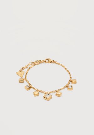 Gullkjede armbånd med firkantede anheng, noen med klare steiner, og et trekantet merkelapp nær låsen, vist på hvit bakgrunn.