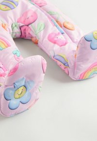 Coussin de cou rose rembourré avec des imprimés de fleurs de dessin animé et de personnages souriants. Présente des extrémités arrondies et des motifs colorés et fantaisistes.