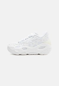 Hvide atletiske sneakers med et struktureret mesh-overdel, rund tå og en kraftig sål med cirkulære udskæringer til ventilation.