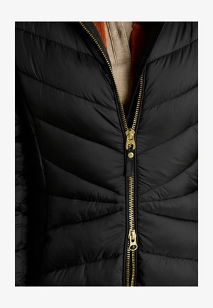 Czarna kurtka puchowa z pikowanym wzorem, z złotymi zapięciami i kontrastującymi teksturami. Kołnierz jest nałożony na spodzie.