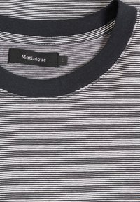 Gestreiftes T-Shirt mit einem marineblauen Rundhalsausschnitt, aus weichem Stoff, mit dünnen horizontalen weißen Streifen und einem Etikett mit der Aufschrift "Matinique L."