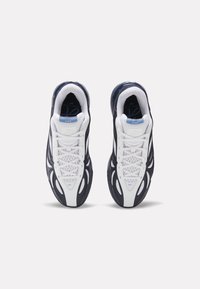 Ζευγάρι λευκά και σκούρα μπλε αθλητικά παπούτσια με πλέγμα και συνθετικές επικαλύψεις, σε θέα από πάνω, πάνω σε λευκό φόντο.