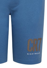 Blue cotton shorts with a smooth texture. Features a side pocket and printed logo "CR7 NIGHTWEAR" in contrasting brown and white.