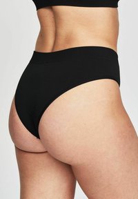 Zwarte katoenen hipsteronderbroek met een gladde textuur, ontwerp met hoge taille en naadloze zijkanten, die een minimalistische stijl benadrukt.