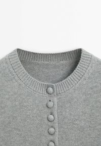 Pullover grigio chiaro in maglia con scollo rotondo, adornato da sei bottoni in tinta lungo la parte anteriore e texture a coste al colletto e alla patta dei bottoni.