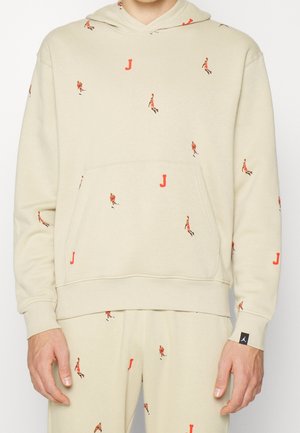 Beiges Hoodie- und Hosen-Set mit kleinen roten Basketballspieler- und Buchstabe-J-Mustern, Fronttasche und schwarzem Logotag am Ärmelbund.