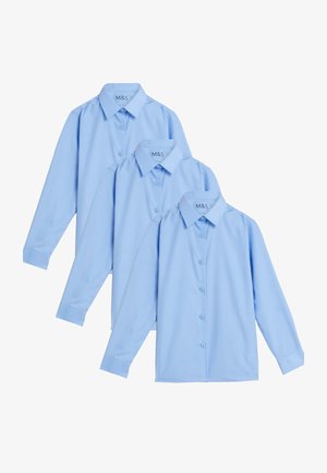 Lysblå langærmet skjorte med knapper, parret med grå skræddersyede bukser. Outfitet har en slank pasform med en glat tekstur og mørke sko.