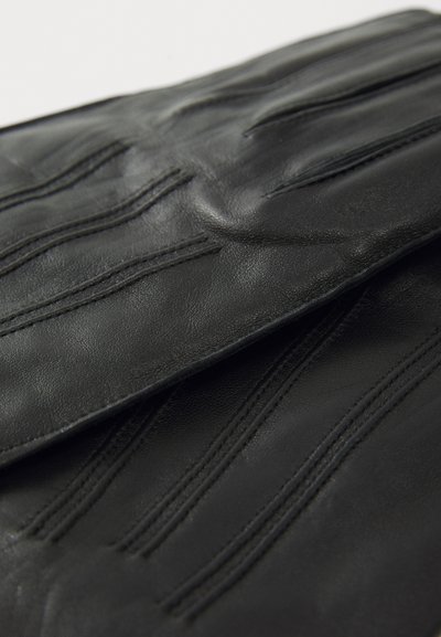 Sorte læderhandsker med syet detaljering på fingrene og bagsiden, vist i nærbillede på en hvid baggrund.