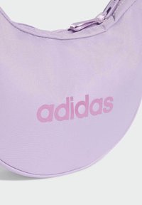 Borsa circolare viola con stoffa liscia, dotata di un logo "adidas" rosa lucido e una chiusura con zip.