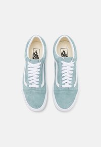 Baskets en suède bleu clair avec des lacets blancs, une bande latérale blanche et un col rembourré. Présente un logo sur la languette et une semelle en caoutchouc.