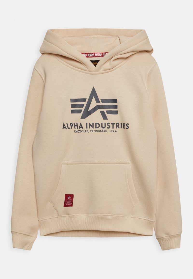 Felpa beige con logo Alpha Industries e testo "Knoxville, Tennessee, U.S.A.", tasca frontale e etichetta rossa vicino all'orlo.