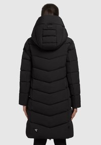 Parka acolchada negra con diseño de chevrones y una gran capucha. Incluye costuras visibles y un logo cerca del dobladillo. Mangas largas y hasta la rodilla.