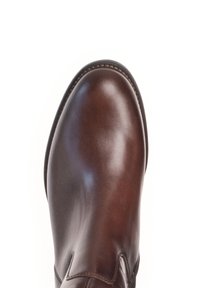 Bottine en cuir marron avec une finition lisse, bout arrondi et détails cousus le long de la semelle. Design minimaliste et silhouette élégante.