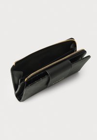 Zwarte leren portemonnee met een textuurafwerking, gouden ritssluiting en meerdere vakken voor kaarten en cash. Kenmerkt een logo-accent.