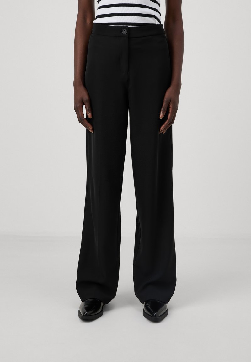 Pantalons larges noirs en tissu lisse. Dotés d'une fermeture à bouton, de poches avant et d'une coupe ajustée pour une silhouette nette.