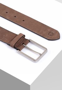 Ceinture en cuir marron avec une boucle rectangulaire en argent, comportant plusieurs trous pour l'ajustement et une texture lisse. Détail cousu à l'extrémité.