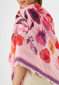 Bloemige sjaal van roze stof met levendige aquarel-stijl bloemen, franjes aan de randen en een paarse rand met stippenaccenten.