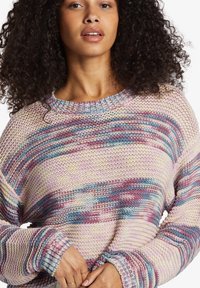 Maglione in maglia dai colori pastello con un motivo a righe ondulate. Presenta un collo rotondo e polsini a costine. Tessuto morbido e testurizzato.