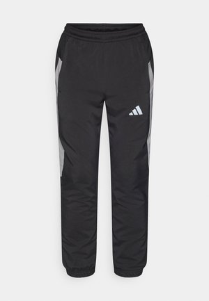 Svarte treningsbukser med elastisk linning, med grå sidepaneler og en hvit adidas-logo på venstre ben, laget av et glatt materiale.