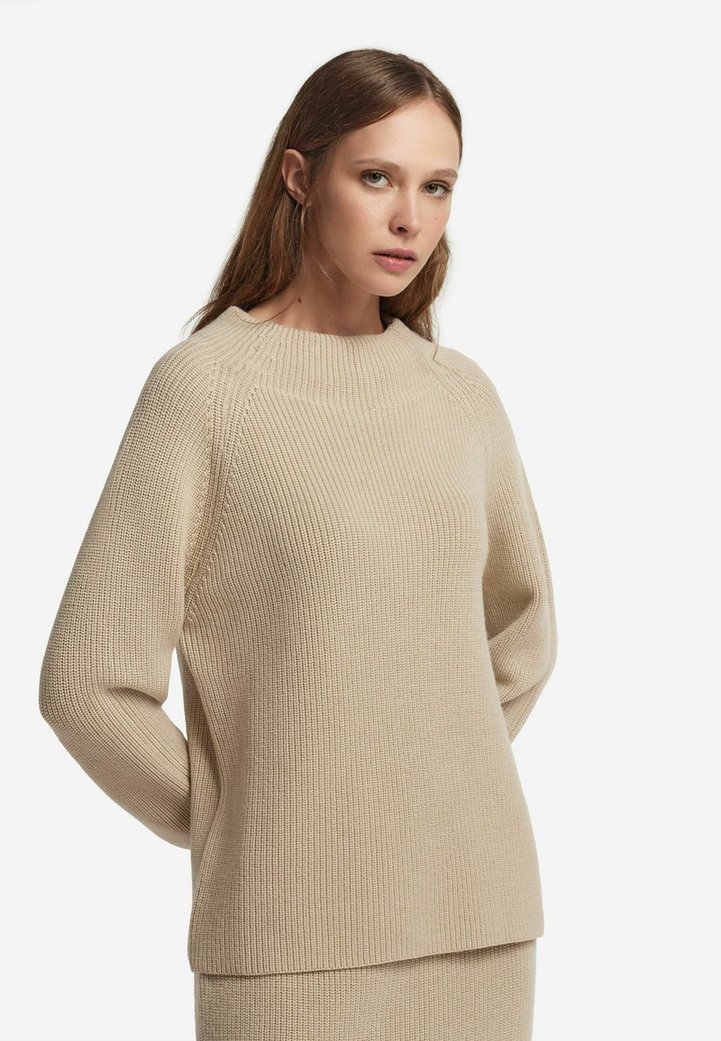 Beige, gerippter Strickpullover mit Rundhalsausschnitt und lockerer Passform. Verfügt über lange Ärmel und einen geraden Saum, was ein strukturiertes Erscheinungsbild verleiht.
