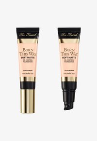 Deux tubes de 30 ml de fond de teint Too Faced Born This Way, avec une finition mate douce, un emballage de couleur pêche, des accents dorés et des capuchons noirs.