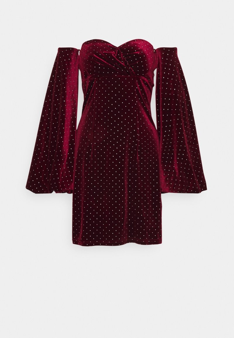 Mini-robe en velours bordeaux épaules dénudées, avec manches longues et larges et petits clous argentés dispersés sur tout le tissu.