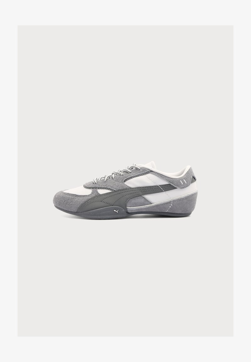 Baskets Puma profil bas gris et blanc avec détails en daim et mesh, lacets et semelle courbée sur fond clair uni.