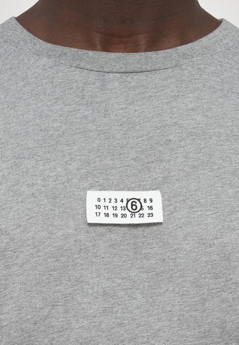 Gray cotton sweatshirt with a round neckline, featuring a white label with numbered graphic detailing stitched on the front.