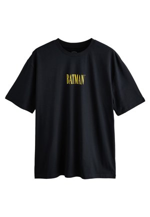 Camiseta negra de algodón con mangas cortas. Presenta un logo de texto amarillo "BATMAN" centrado en el pecho. Diseño clásico de cuello redondo.
