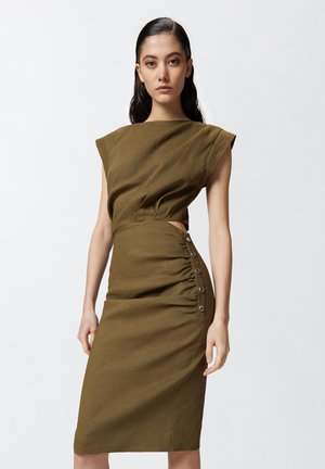 Robe vert olive avec une silhouette ajustée, des manches courtes, une découpe latérale et des boutons décoratifs le long du côté froncé. Texture de tissu lisse.