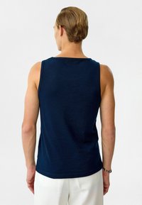 Navyblauwe top zonder mouwen van katoen, met een zachte structuur en brede schouderbanden. Van achteren weergegeven, met een eenvoudig ontwerp.
