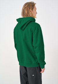 Green hoodie with a hood, made from a soft fabric. Features a relaxed fit and ribbed cuffs. Plain design, no patterns or accents visible.