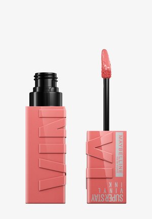 La couleur à lèvres Maybelline SuperStay Vinyl Ink dans un tube rectangulaire rose avec logo en relief. Livré avec un applicateur noir et une pointe douce.