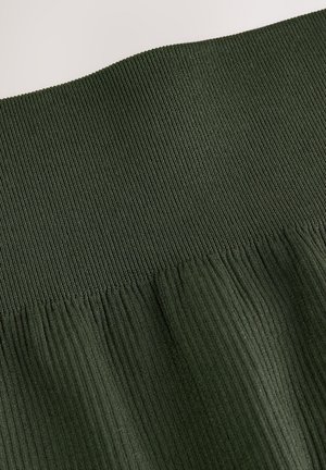 Tissu vert foncé côtelé présentant une surface texturée, avec une ceinture froncée et de subtiles plissures dans la partie inférieure.