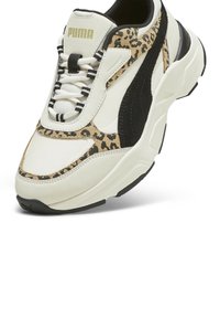 Sneaker PUMA con tomaia in pelle bianca con accenti neri e un design a stampa leopardata. Suola spessa con battistrada in gomma nera testurizzata.