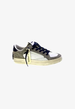 Sneaker in suede grigio e bianco con lacci blu navy, suola bianca sporca e un'etichetta gialla con scritto "Some London" attaccata ai lacci.